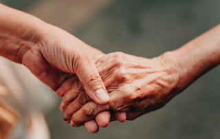 A caregiver holds hands with a senior loved one