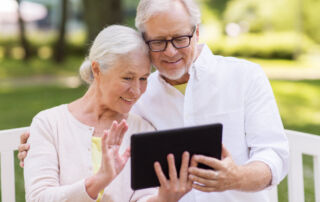 A senior couple uses a tablet to video chat