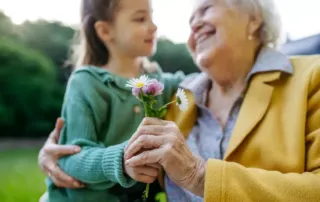 A grandmother smiling with her granddaughter.
